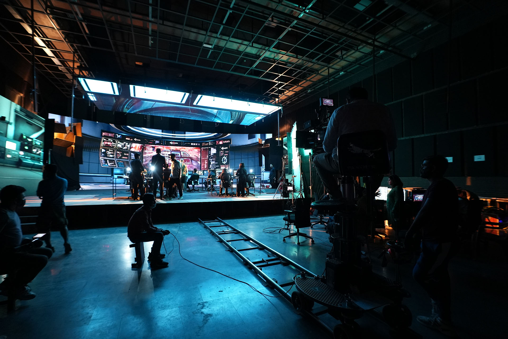 A production studio with a track and large camera filming a stage