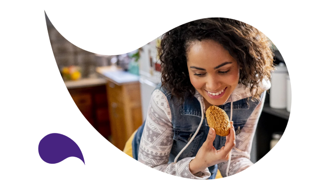 A person eating a cookie at the table