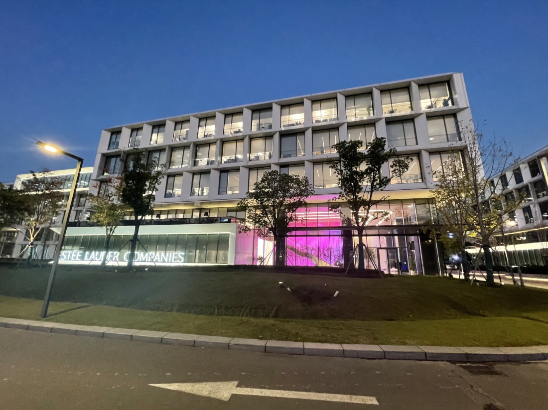 Outside the Estee Lauder companies building lit up in pink
