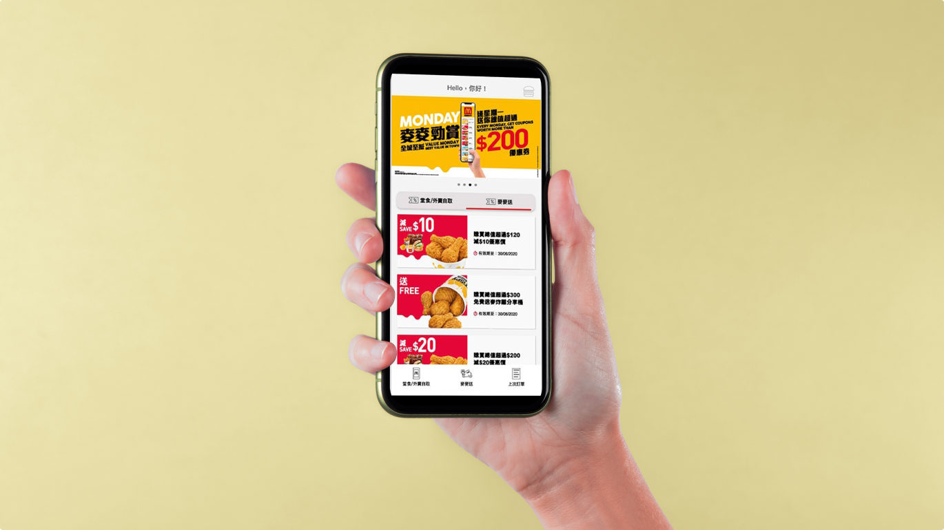 A hand holding a phone using the McDonald's app
