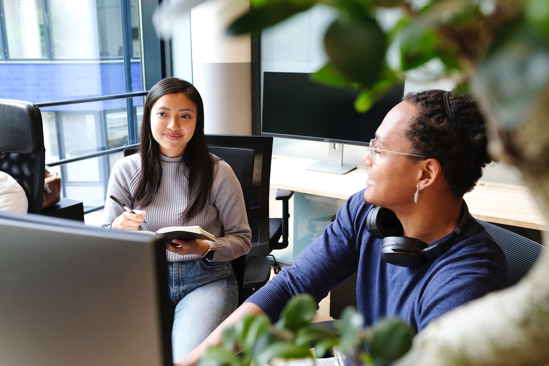 Two employees chatting at their desks