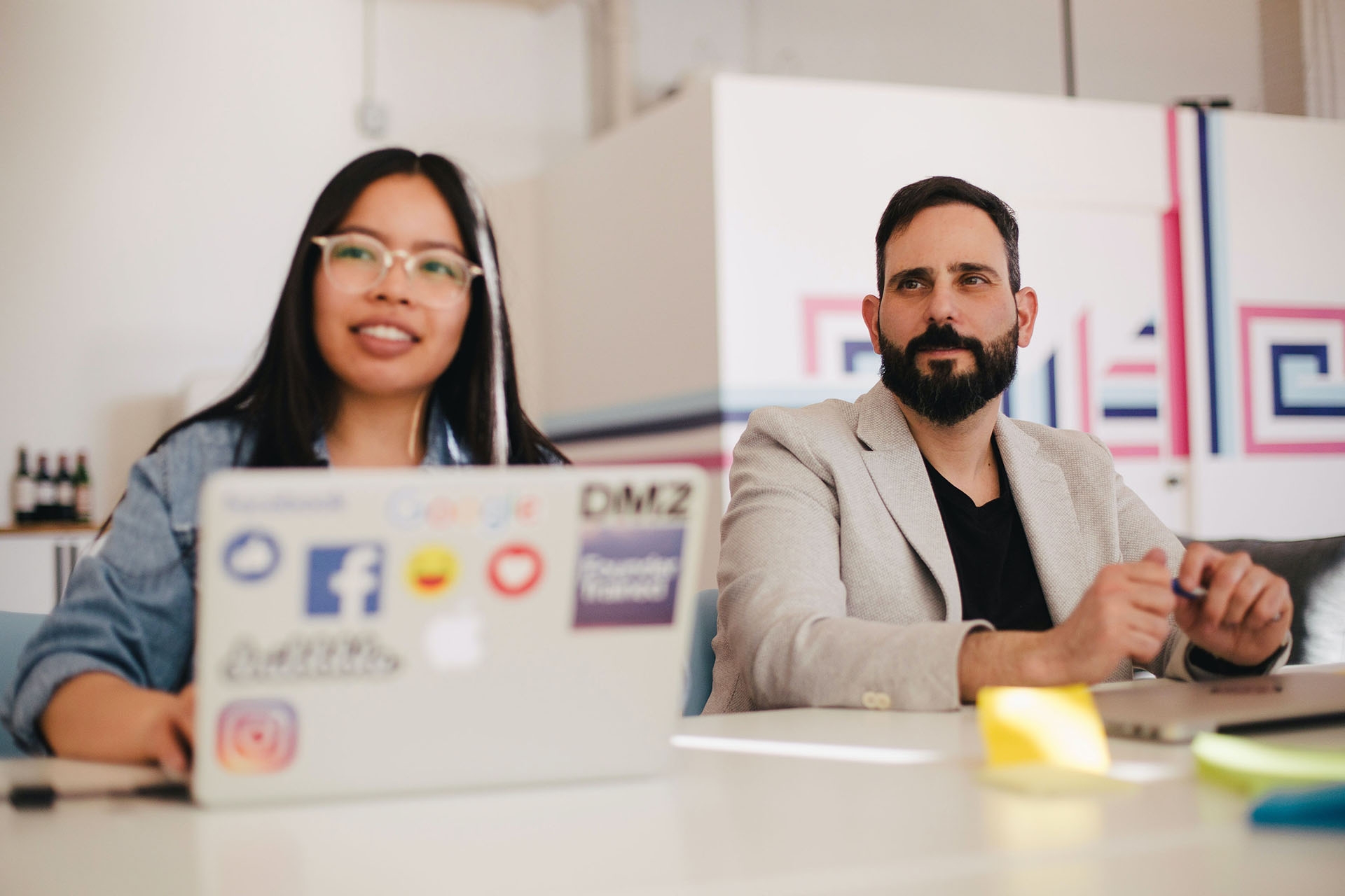 Two employees in a meeting on laptops