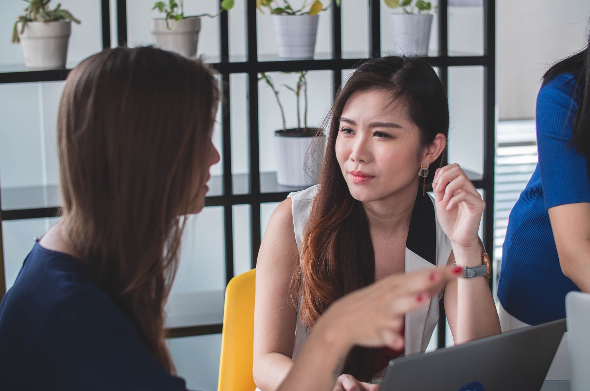 Two employees chatting at their desks