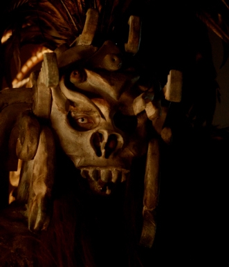 A masked monster stares in the dark