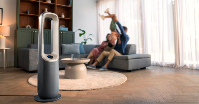 A family having fun in a living room with a phillips fan on display
